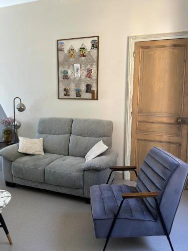 a living room with a couch and a chair at Part des Anges - Gîte Hautvillers in Hautvillers