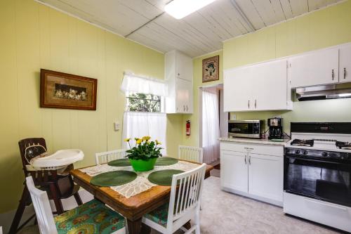 a kitchen with a table and a kitchen with white cabinets at Peaceful Pomona Park Home 1 Mi to Lake Broward! in Satsuma