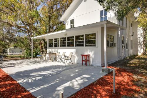 a white house with a red table and chairs at Peaceful Pomona Park Home 1 Mi to Lake Broward! in Satsuma