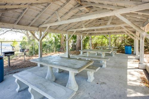 a group of picnic tables sitting under a pavilion at Peaceful Pomona Park Home 1 Mi to Lake Broward! in Satsuma