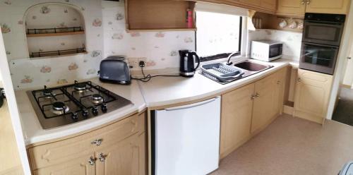 a small kitchen with a stove and a sink at Culver in Newport