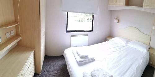 a small bedroom with a white bed and a window at Culver in Newport