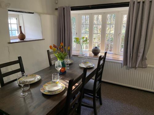 a dining room table with plates and flowers on it at Cottage Retreat Snowdonia in Capel-Curig
