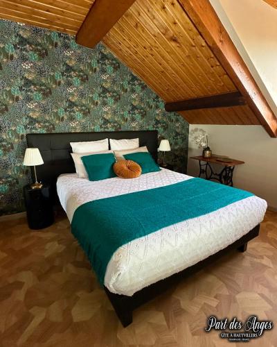 a bedroom with a large bed with a green comforter at Part des Anges - Gîte Hautvillers in Hautvillers