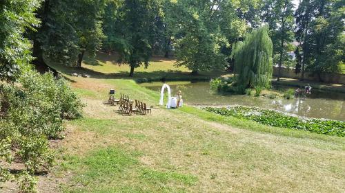 a group of tables and chairs next to a pond at Hotel Zámecká Sýpka in Blansko
