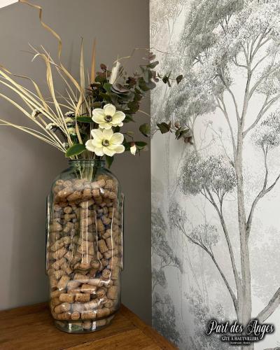 a vase with flowers in it sitting on a table at Part des Anges - Gîte Hautvillers in Hautvillers