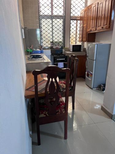 a kitchen with a wooden table and a wooden chair at Apex guest facility in Buea