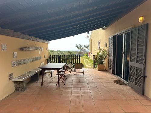 a patio with a table and chairs and a fence at La casa di Sara in Capo Sperone