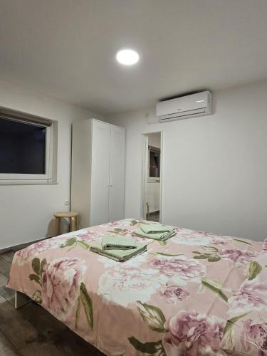 a bedroom with a bed with a floral bedspread at A&M studio apartman in Otočac