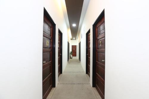 a hallway with dark wood doors and a white wall at Hotel O Ady Hotel in Kuala Terengganu