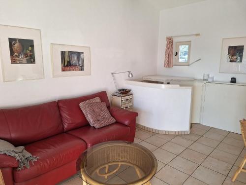 un salon avec un canapé rouge et une table dans l'établissement Bleu Horizon, à Cavalaire-sur-Mer