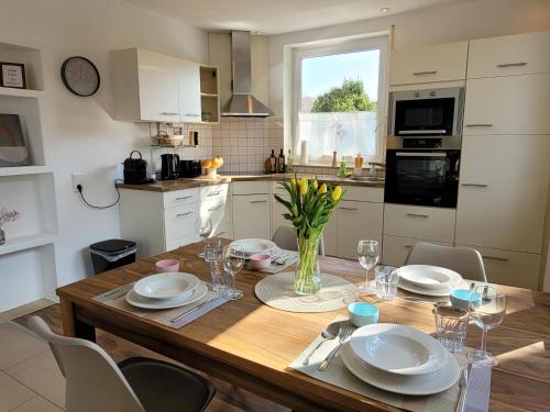 a kitchen with a wooden table with plates and glasses at Ferienwohnung Ankerplatz Wangen in Öhningen