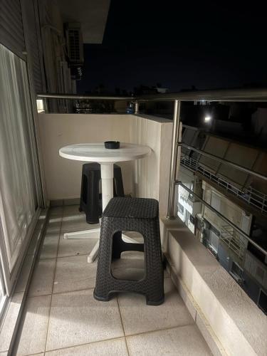 a small table and chair on a balcony at night at Blue Maizon in Heraklio Town