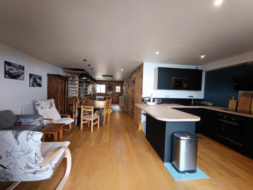 une cuisine et un salon avec une table et des chaises dans l'établissement Résidence Maison Bleue Charrette - Appartement-Chalet individuel refait à neuf - Luxe - Garage - MAE-5154, à Montgenèvre
