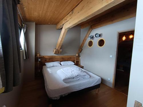 une chambre avec un lit et un plafond en bois dans l'établissement Résidence Maison Bleue Charrette - Appartement-Chalet individuel refait à neuf - Luxe - Garage - MAE-5154, à Montgenèvre