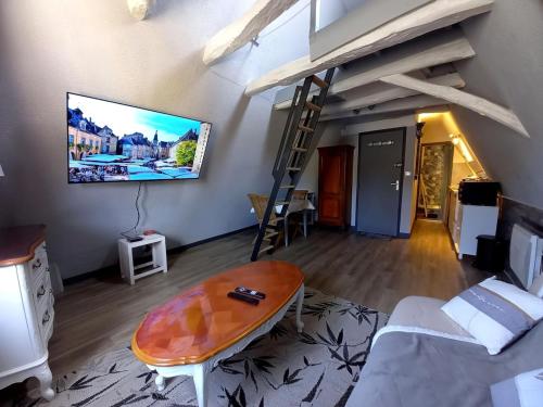 un salon avec un canapé et une télévision au mur dans l'établissement Studio Noem, à Sarlat-la-Canéda