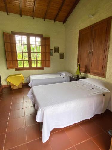 a bedroom with two beds and a window at Finca chalet El Robledal in Pueblo Tapao