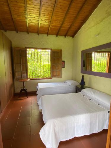 a room with four beds and two windows at Finca chalet El Robledal in Pueblo Tapao