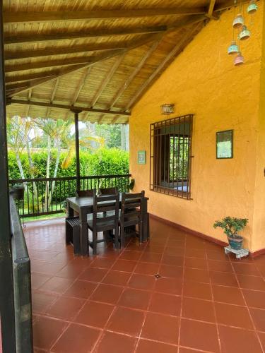 a patio with a table and benches on a yellow wall at Finca chalet El Robledal in Pueblo Tapao