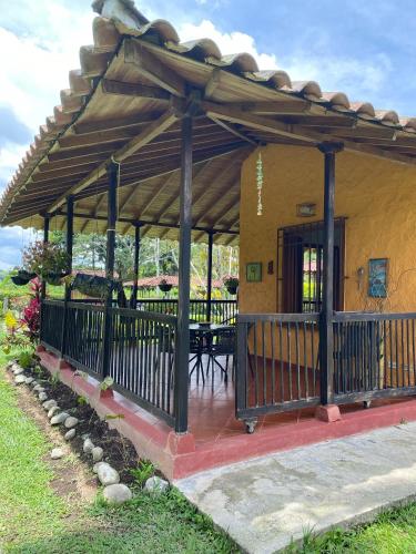 a pavilion with a table and chairs under a roof at Finca chalet El Robledal in Pueblo Tapao
