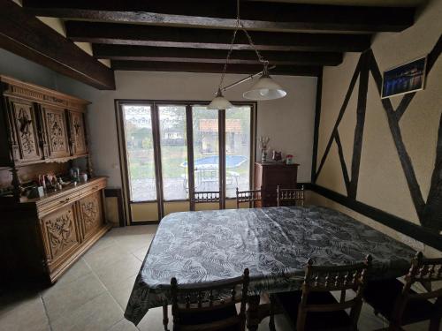 une salle à manger avec une table et des chaises et une grande fenêtre dans l'établissement Gite du Puits Tournant - Chambre 1, à Poilly-lez-Gien