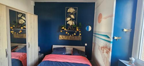 - une chambre avec des murs bleus et 2 lits dans l'établissement Appartement avec terrasse proche plages et sentiers de randonnée, à Perros-Guirec