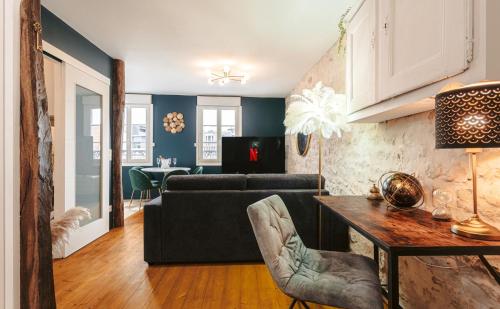 un salon avec un canapé et une table dans l'établissement Gatsby - Élégant, Central, Fibre, Tv 4K, Netflix, Literie Confortable, à La Rochelle