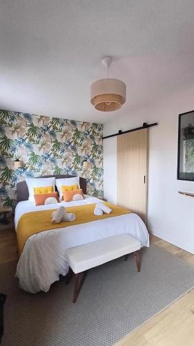 ein Schlafzimmer mit einem großen Bett und gelben und orangen Kissen in der Unterkunft Le Colibri - studio paisible et raffiné au sud d'Aix in Aix-en-Provence
