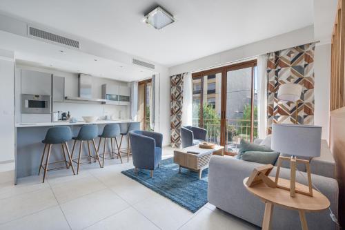 Il dispose d'une cuisine et d'un salon avec un canapé et des chaises. dans l'établissement Magnifique T3 wifi, garage et climatisation à 5 min de la plage, à Beaulieu-sur-Mer