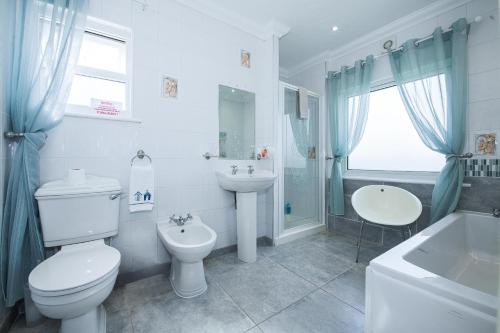 a white bathroom with a toilet and a sink at OYO Pier Hotel in Clacton-on-Sea