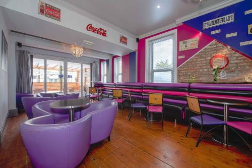 a restaurant with purple chairs and tables and a brick wall at OYO Pier Hotel in Clacton-on-Sea