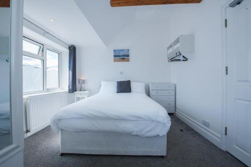 a white bedroom with a white bed and a window at OYO Pier Hotel in Clacton-on-Sea