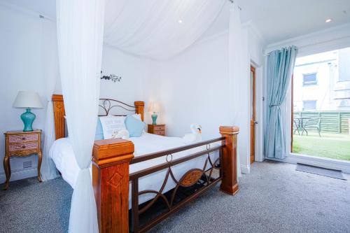 a bedroom with a canopy bed and a window at OYO Pier Hotel in Clacton-on-Sea