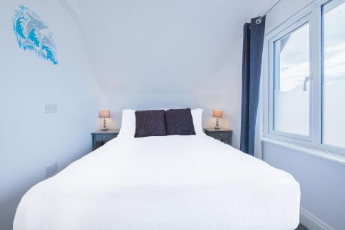 a white bed in a room with a window at OYO Pier Hotel in Clacton-on-Sea