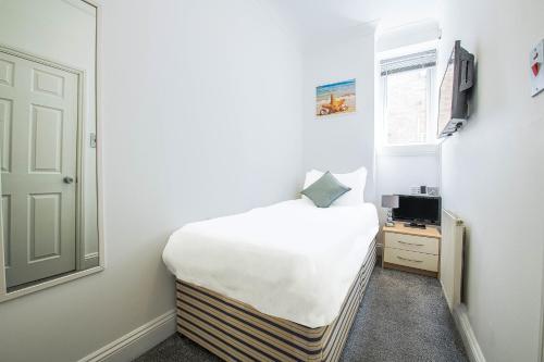 a small bedroom with a bed and a window at OYO Pier Hotel in Clacton-on-Sea