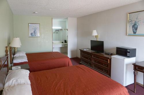 a hotel room with two beds and a flat screen tv at OYO Hotel Altus N Main St in Altus