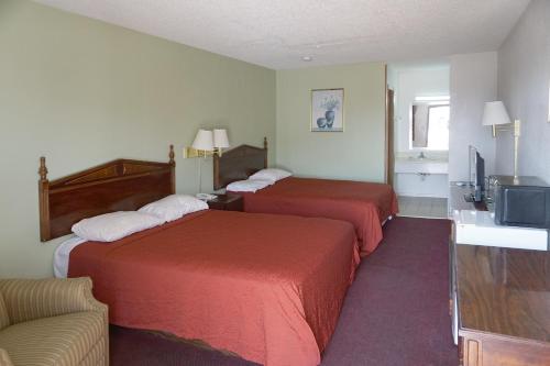 a hotel room with two beds and a television at OYO Hotel Altus N Main St in Altus