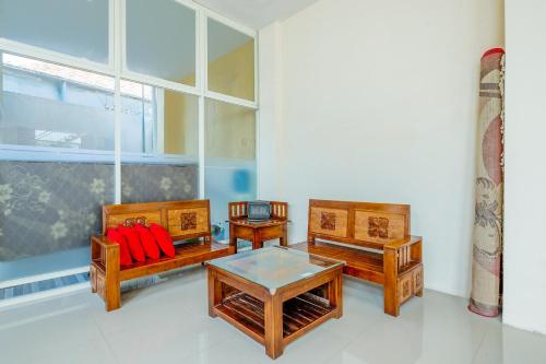 a living room with three benches and a table at OYO 3434 Penginapan Keluarga Syariah in Lamongan