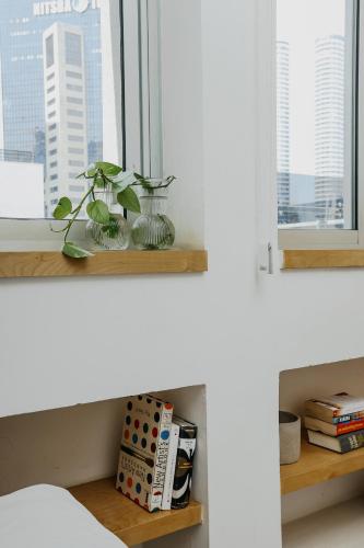 a plant in a glass vase sitting on a window sill at Domus Metro Hotel in Tel Aviv