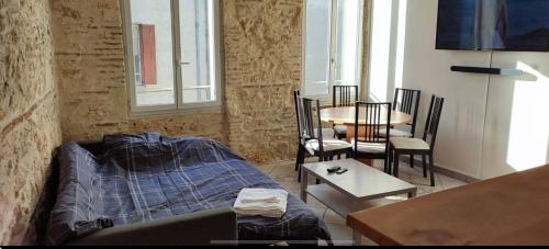 un salon avec un lit, une table et des chaises dans l'établissement Appartement duplex spacieux en hypercentre avec garage privé, à Agen