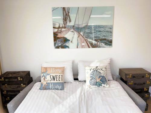 a bed with pillows and a picture of a boat at Magnolia House with Indoor Swimming Pool and Sauna in Tallinn