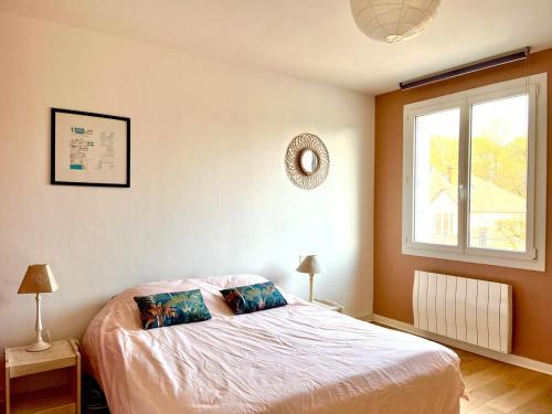 - une chambre avec un lit avec deux oreillers et une fenêtre dans l'établissement Les Prairies Metro B Centre, à Rennes