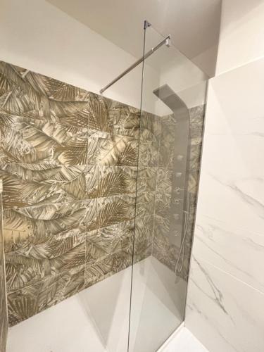a shower with a glass door in a bathroom at Karma apartment in Catania