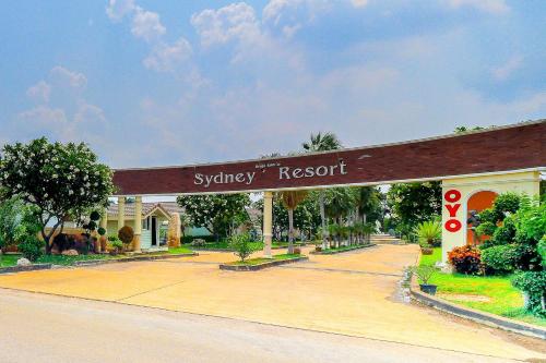 a sign for a shopping resort on the side of a road at OYO 926 Sydney Resort in Ban Don Pho