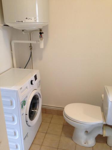 une salle de bain avec machine à laver et toilettes dans l'établissement Logement cœur de Cholet, à Cholet