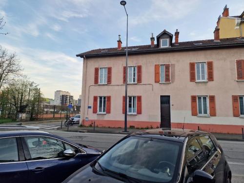グルノーブルにあるAppartement - Grenoble - Calmeの建物前の路上駐車車2台