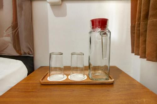 a bottle and two glasses sitting on a table at OYO Life 3415 Penginapan Wimane in Sukarami