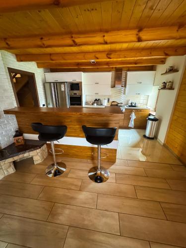 a kitchen with two bar stools in a room at Beskidzki Domek Kurów in Kurów