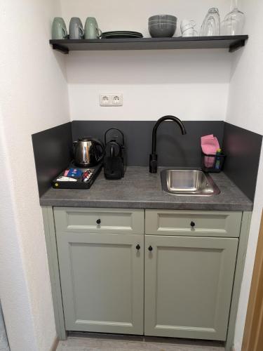 a small kitchen with a sink and a counter at Der Lärchenhof Ferienwohnungen in Schönau am Königssee