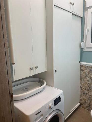 a washing machine in a kitchen with a mirror at A-vli 63 in Volos